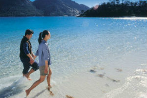 Couple walking in the water in Wineglass Bay