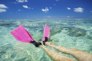 Snorkeller in Pink Flippers floating over the Great Barrier reef